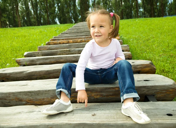 Cute little girl is sitting on stairs — Stock Photo, Image