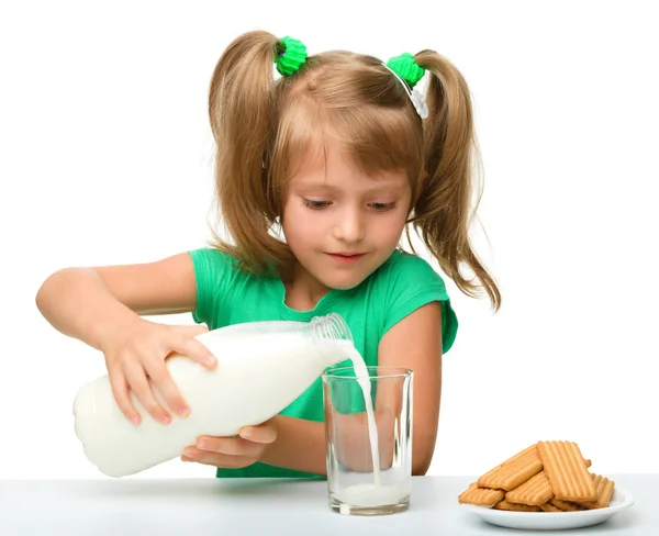 Χαριτωμένο κοριτσάκι ρίχνει το γάλα σε ποτήρι — Φωτογραφία Αρχείου