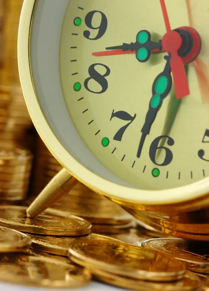 El tiempo es dinero - marcación del reloj y monedas de oro Fotos de stock