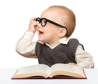 Little child play with book and glasses clipart