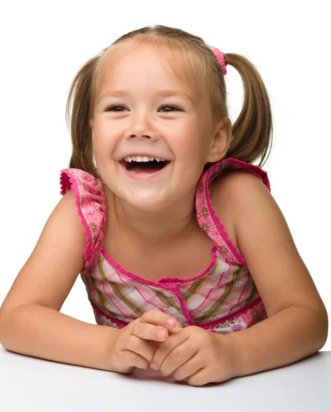 Mutlu küçük kız masada oturuyor — Stok fotoğraf