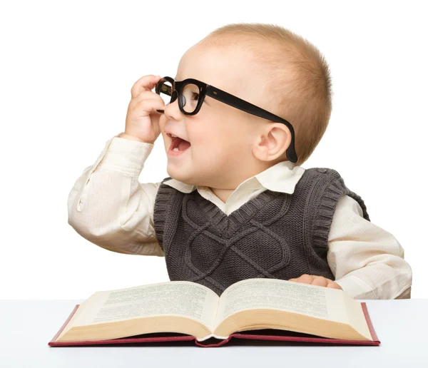 Маленька дитина грає з книгою та окулярами — стокове фото