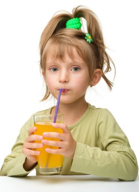 sevimli küçük kız portakal suyu içiyor.