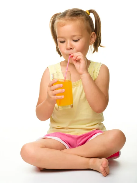 Klein meisje drinken sinaasappelsap — Stockfoto
