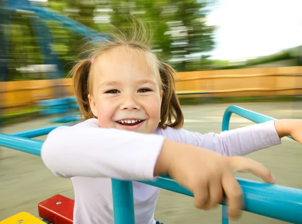 Menina bonito está montando em alegre-go-round — Fotografia de Stock