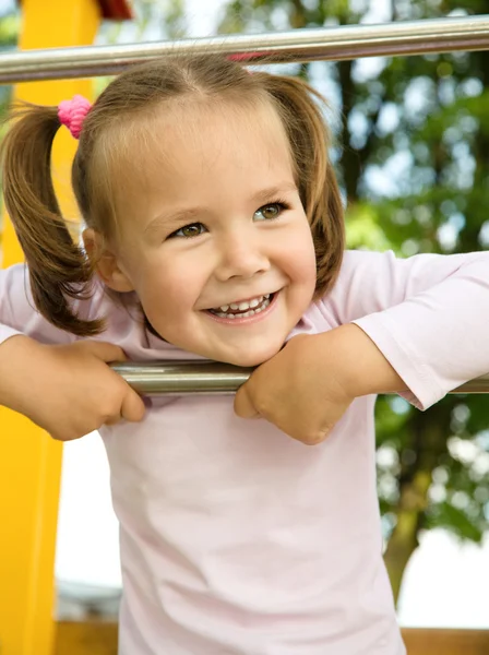 Маленькая девочка играет на детской площадке — стоковое фото