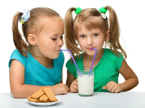 Две маленькие девочки пьют молоко. — стоковое фото