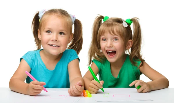 Twee kleine meisjes tekenen met markeringen — Stockfoto