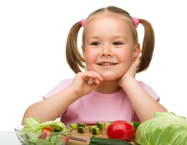 Klein meisje is snijden wortel voor salade — Stockfoto