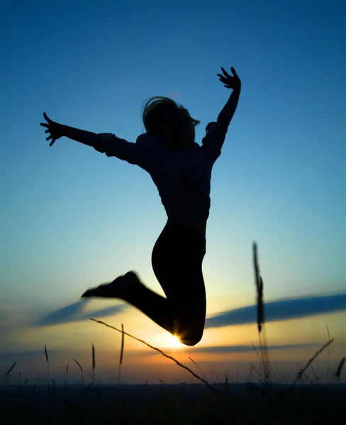 Silueta dívka, která skočila přes slunce — Stock fotografie