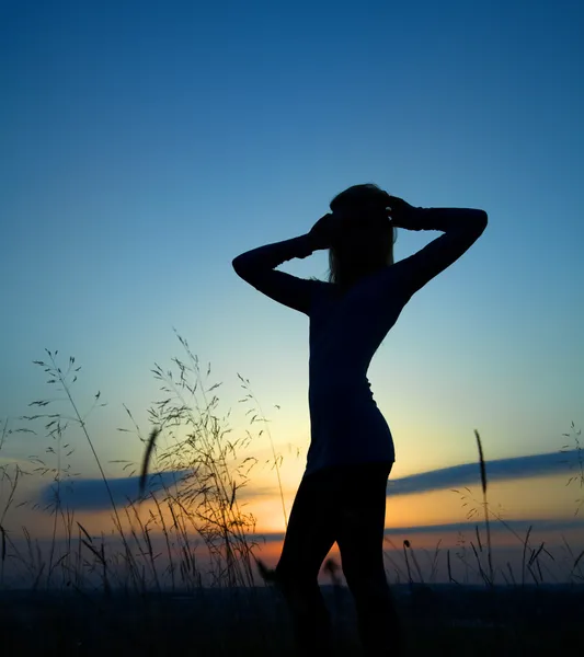 Silhueta de uma menina sobre o pôr do sol — Fotografia de Stock