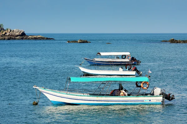 Три лодки на голубой лагуне — стоковое фото