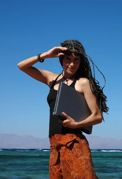 Meisje met laptop op een strand — Stockfoto
