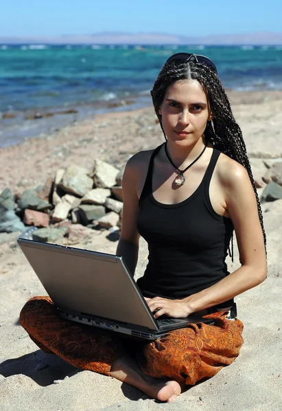 Chica con portátil en una playa Fotos de stock