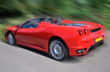 Red sport car on the road clipart