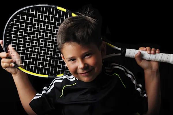 Tennis jongen glimlachend geïsoleerd in zwart — Stockfoto