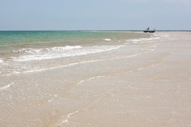 Sandy beach with traditional fishing boat clipart