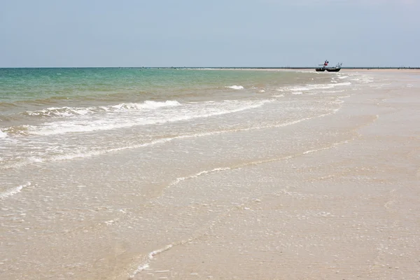 Песчаный пляж с традиционной рыбацкой лодкой — стоковое фото