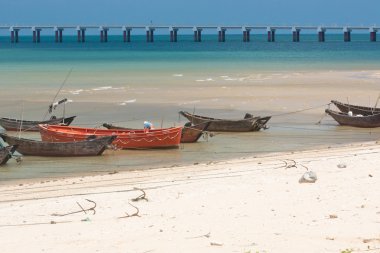 Anchored wooden fishing boats clipart