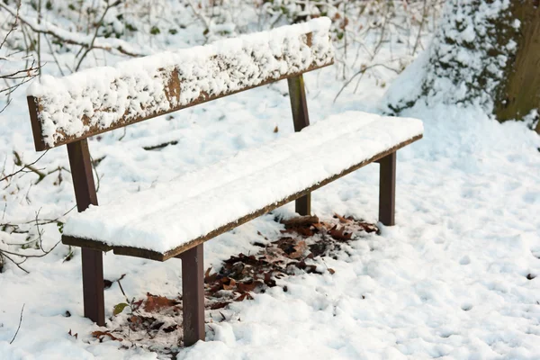 Panchina del parco sotto pacchetto di neve — Foto Stock