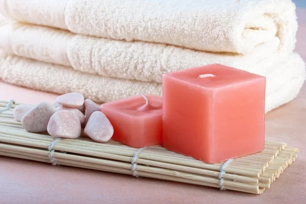 Rode kaarsen en handdoek met perzik achtergrond — Stockfoto