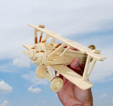 Hand holds the toy plane clipart