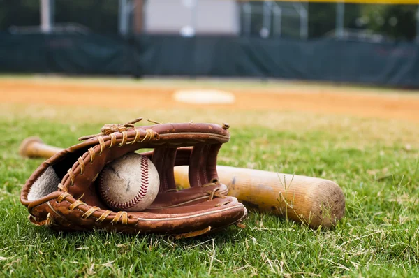 Старый бейсбол, перчатки и летучая мышь на поле — стоковое фото
