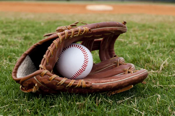 Baseball i gamla handsken på fältet — Stockfoto