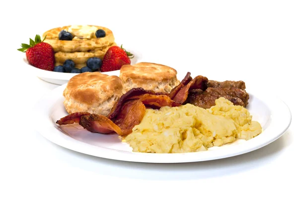 Завтрак с яйцами, беконом, колбасой, печеньем и вафлями — стоковое фото