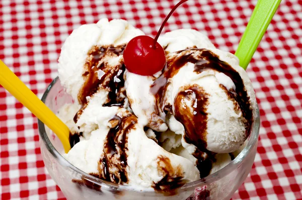 Vaniljglass och skedar med körsbär och choklad topping närbild — Stockfoto