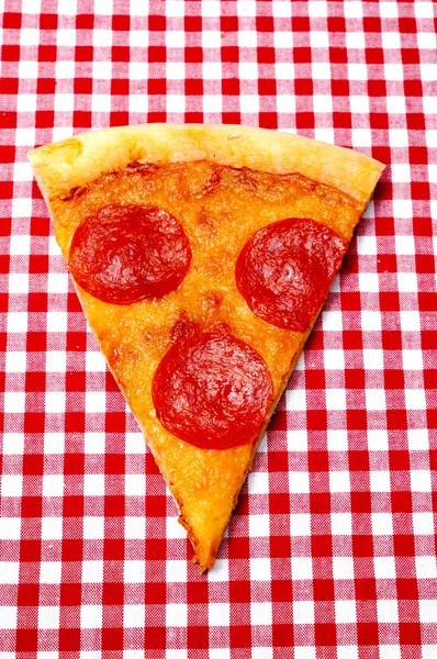 Pepperoni pizza slice op rode pastel close-up — Stockfoto