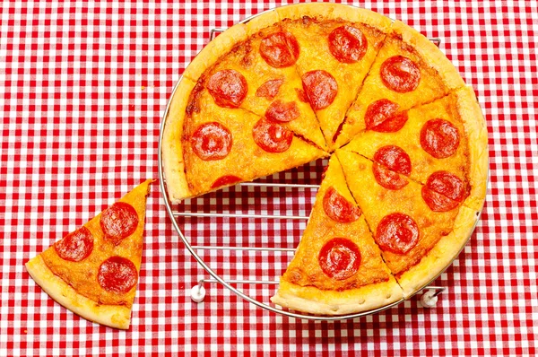 Pizza au pepperoni entier avec tranche enlevée — Photo