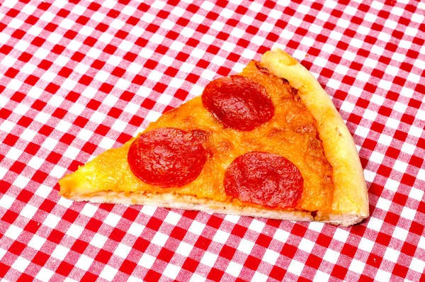 Pepperoni pizza slice op rode pastel — Stockfoto