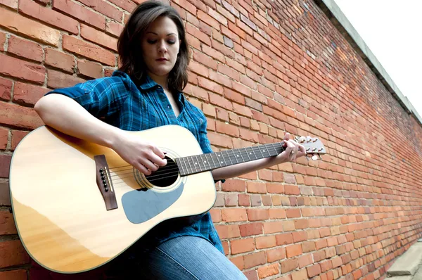 Jonge vrouw spelen gitaar — Stockfoto