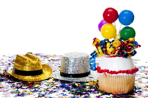 Cupcake, hoeden en confetti op feestje — Stockfoto