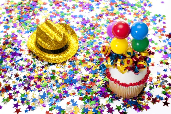 Cupcake, chapeau et confettis à la fête — Photo