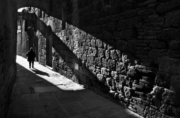 Um pedestre em uma rua medieval estreita — Fotografia de Stock