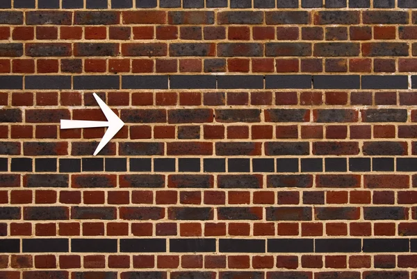 れんが造りの壁の矢印 — ストック写真