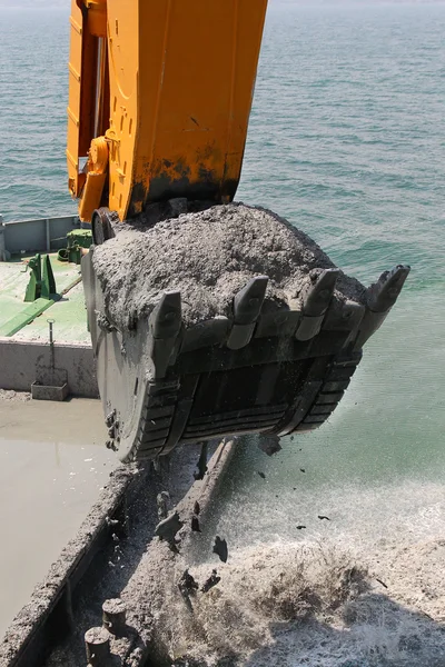 Cubo de la excavadora cargas de agua el suelo desde el fondo del mar hasta el —  Fotos de Stock