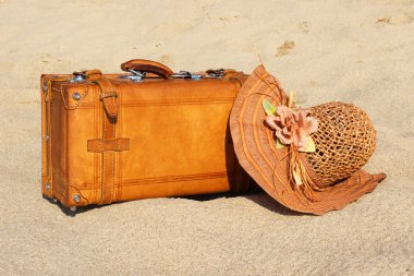 Trunk and bonnet on the sand clipart