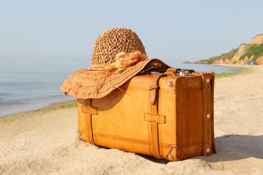 Yellow beautiful suitcase on a sea-shore clipart