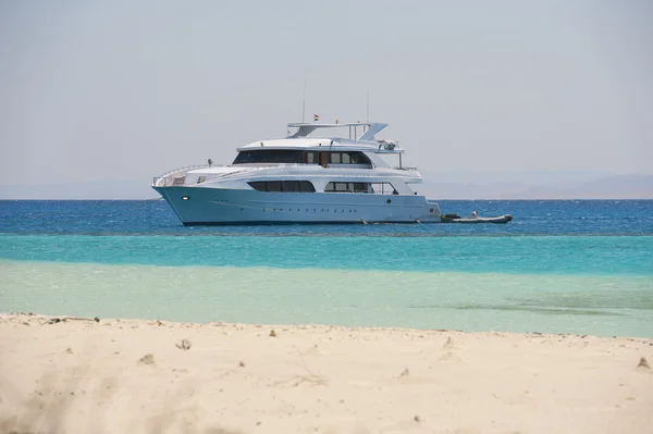 Large motor yacht moored off a tropical beach — Stock Photo, Image