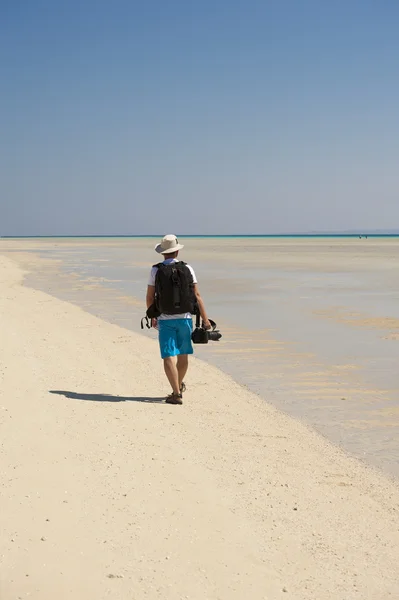 Фотограф, гуляющий по тропическому пляжу — стоковое фото