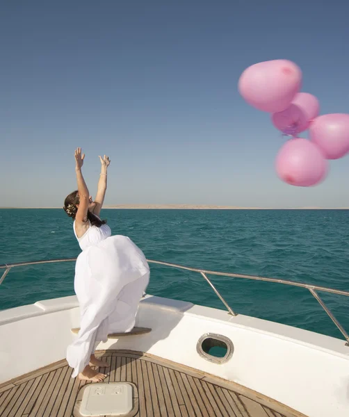 Bruid vrijgeven van ballonnen vanaf een boot — Stockfoto