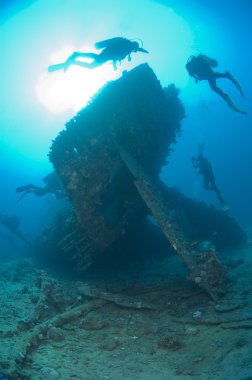 Divers exploring a large shipwreck clipart
