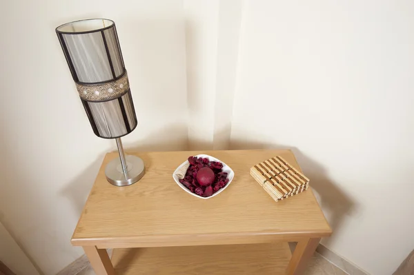 Маленький стол с лампой и украшением — стоковое фото