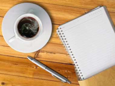 White cup of hot coffee and blank page note book clipart