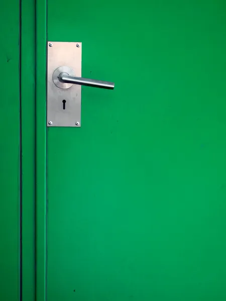 Metal door handle on green — Stock Photo, Image