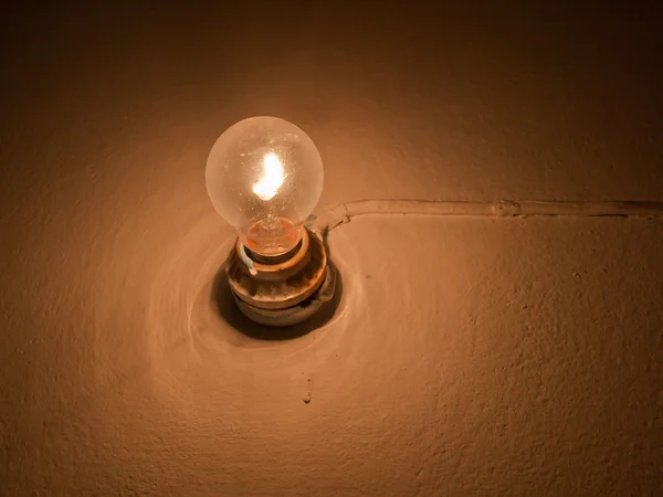 Старая лампочка на стене — стоковое фото