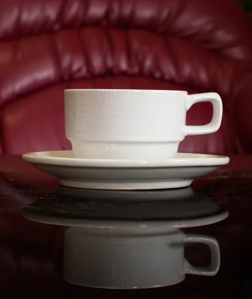 Blanco taza de café en Negro mesa de reflexión — Foto de Stock
